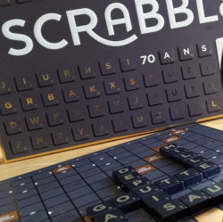 Scrabble lance une édition limitée au design nouveau et sophistiqué : Scrabble 70e Anniversaire avec un plateau et des jetons noirs et or.