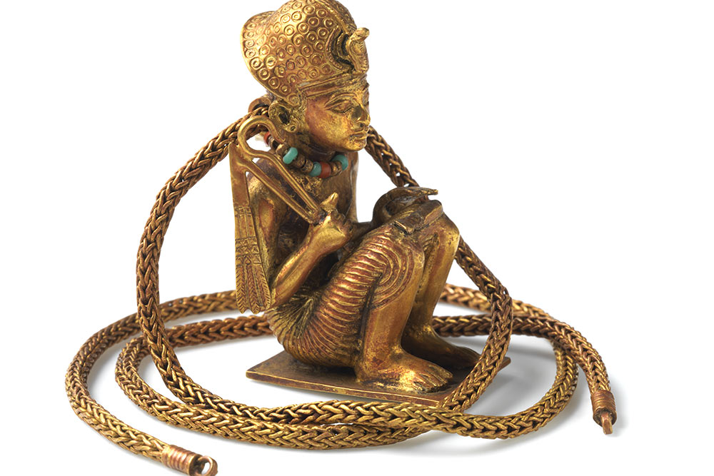 Figurine prosternée et chaîne en or représentant un roi accroupi