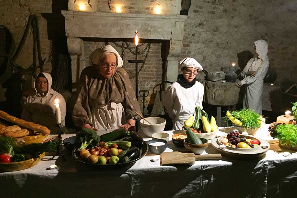 Une grand-mère et son petit fils s'affairant dans les cuisines du château