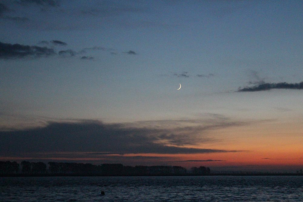 La lune fait son apparition, le ciel devient rouge et la mer noire