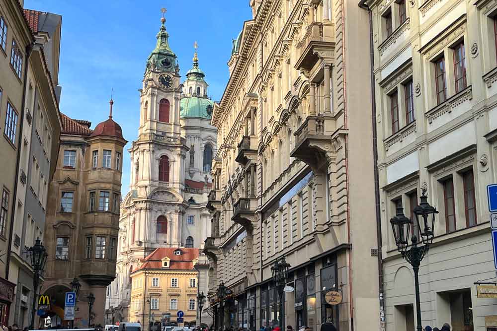Rue montant vers le château de Prague. Au fond, l’église Saint-Nicolas