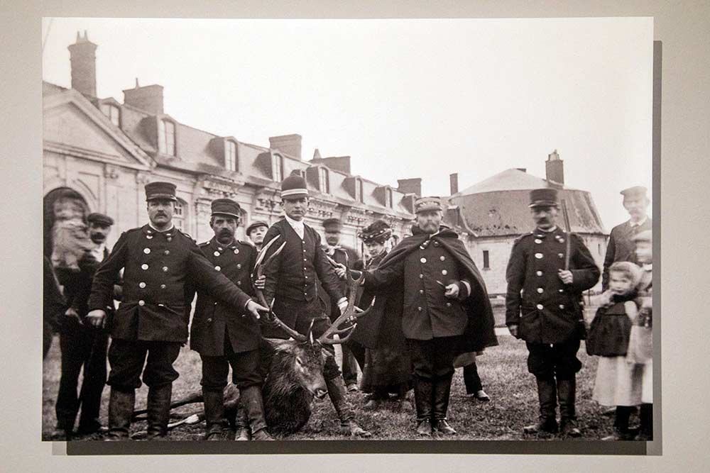 La présentation du cerf, au pied de l’enceinte basse du château, par le garde et le gouverneur de Chambord (1906). © Georges Dreux, Collection famille Dreux.