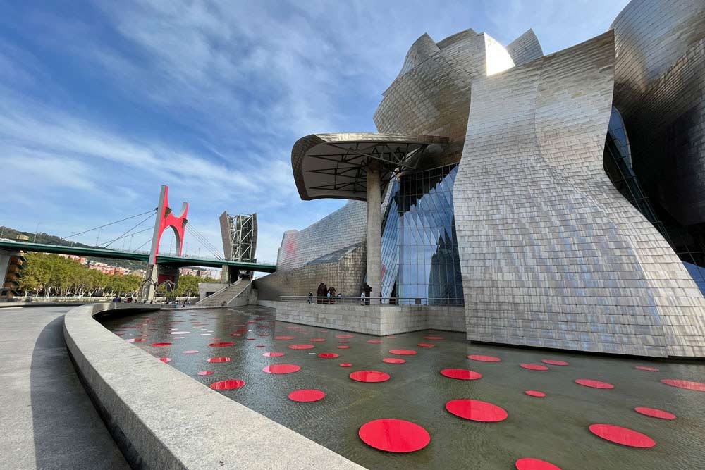 Guggenheim Bilbao - avec une installation de Yayoi Kusama (dans le bassin) et au fond, Les Arcs rouges de Buren