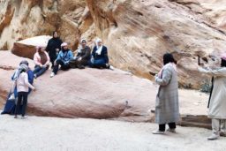 Des touristes prennent la pause sur un rocher à l’entrée du site.