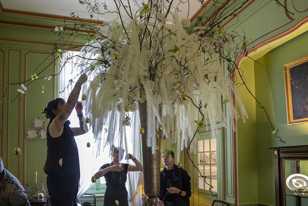 Dans une pièce plus petite, les apprentis s’affairent à la réalisation d’un immense bouquet blanc…