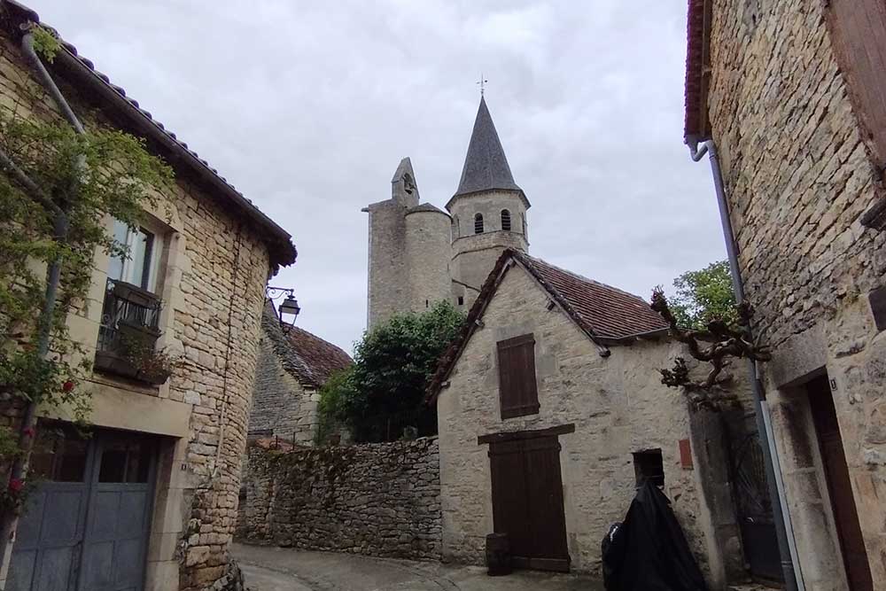 Villeneuve-d’Aveyron - L’église de Villeneuve vue depuis une rue montante.
