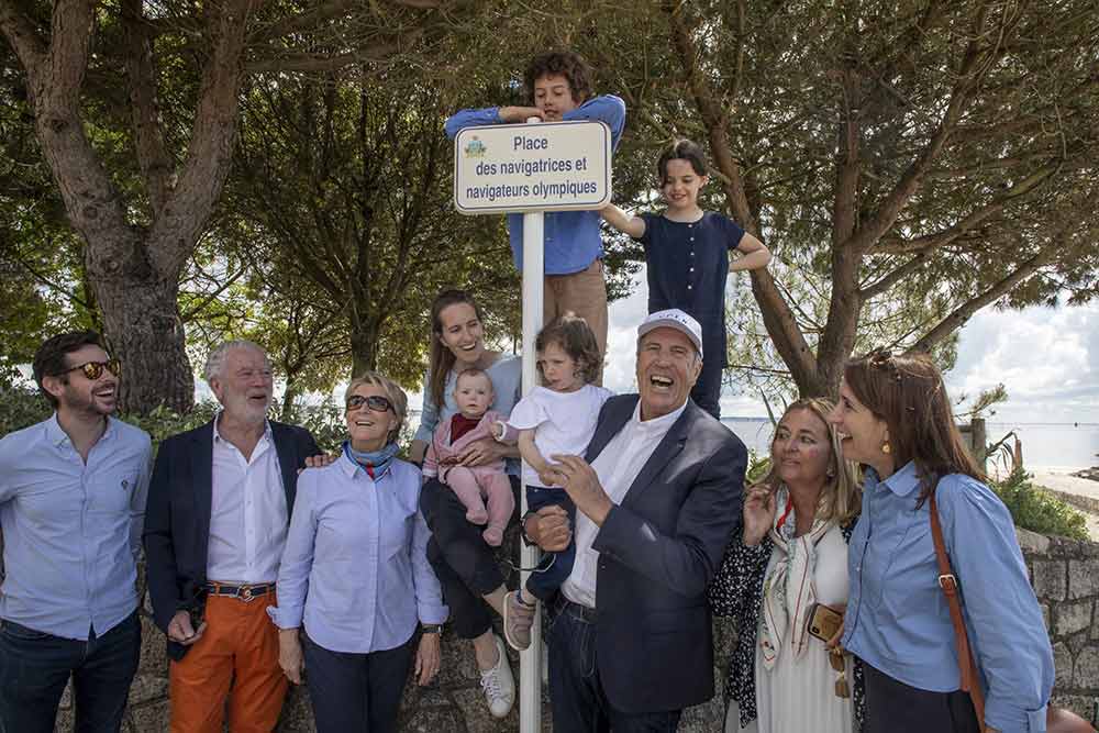 Casquette blanche La Baule sur la tête, Marc Pajot pose avec fierté en souriant avec ses enfants et ses petits-enfants, sous la plaque tout juste dévoilée.