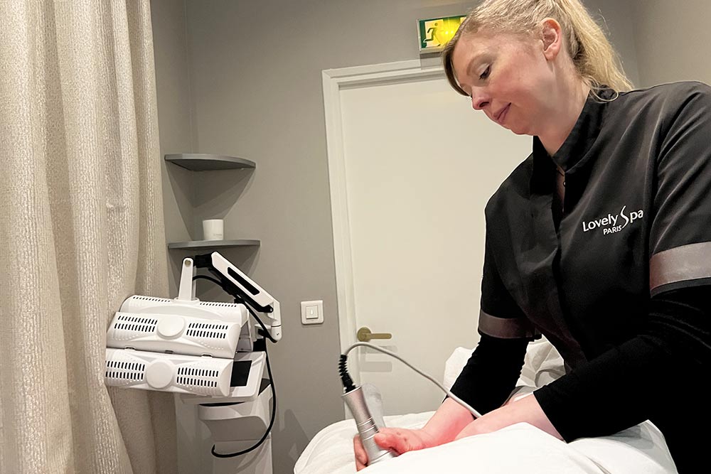 Stéphanie en train d'effectuer un soin avec La Radiofréquence Hexapolaire sur les jambes de la cliente.