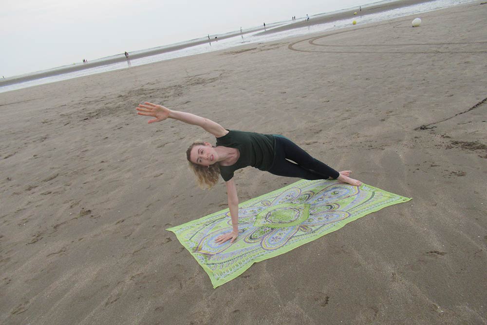 Belinda - pratique le Pilates sur la plage.