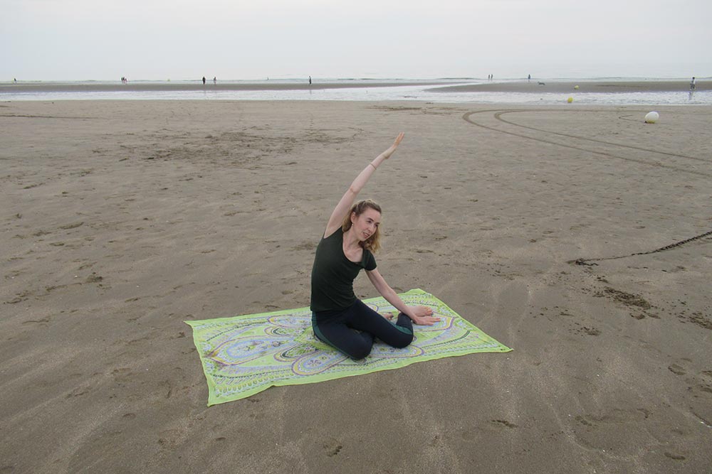 Belinda - pratique le Pilates sur la plage.