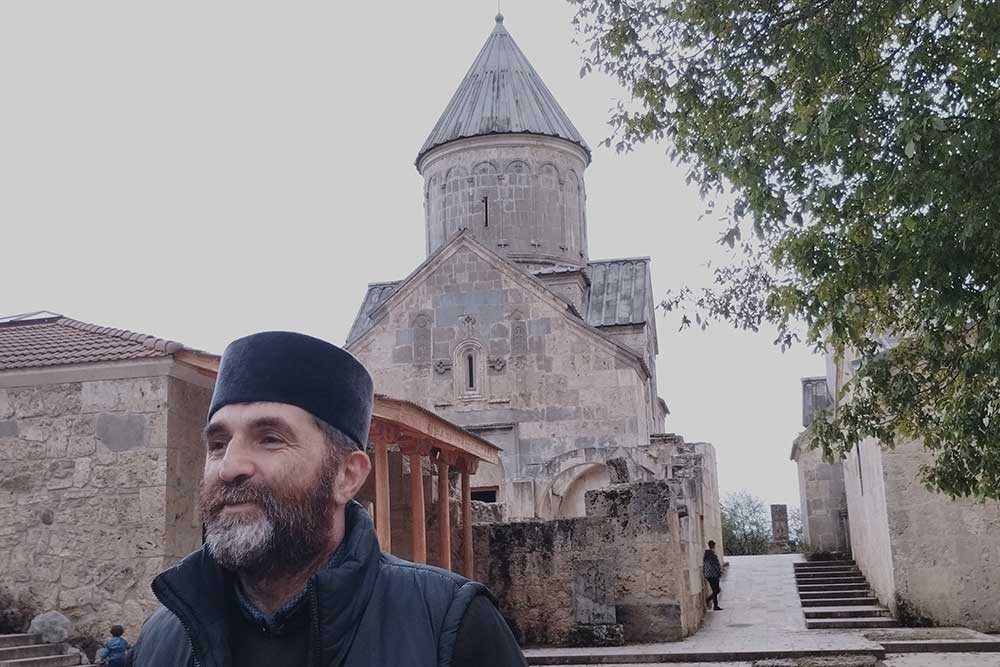 Monastère - Un prêtre attend ses ouilles devant le monastère de Haghartsin.