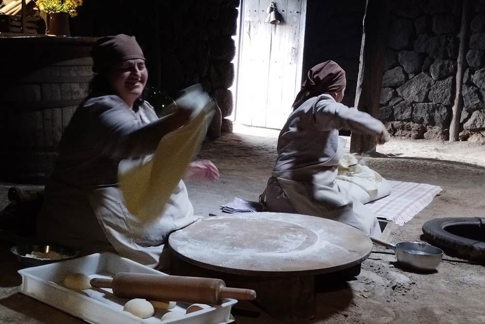 Des femmes montrent comment réaliser le « lavash » dans une ancienne boulangerie restaurée. Le four est creusé dans le sol.