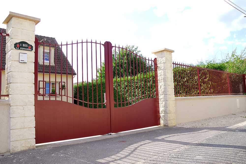 Portail - Un beau portail en métal bordeaux.