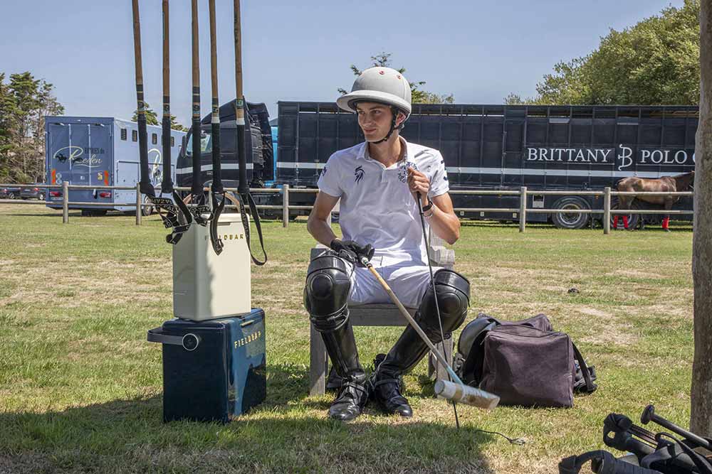 Le jeune champion français de polo Elouan Badarello s’apprête à jouer la demi-finale Tente d’Or. À ses côtés, les boissons sont maintenues fraîches dans une des glacières Fieldbar. © Caroline Paux