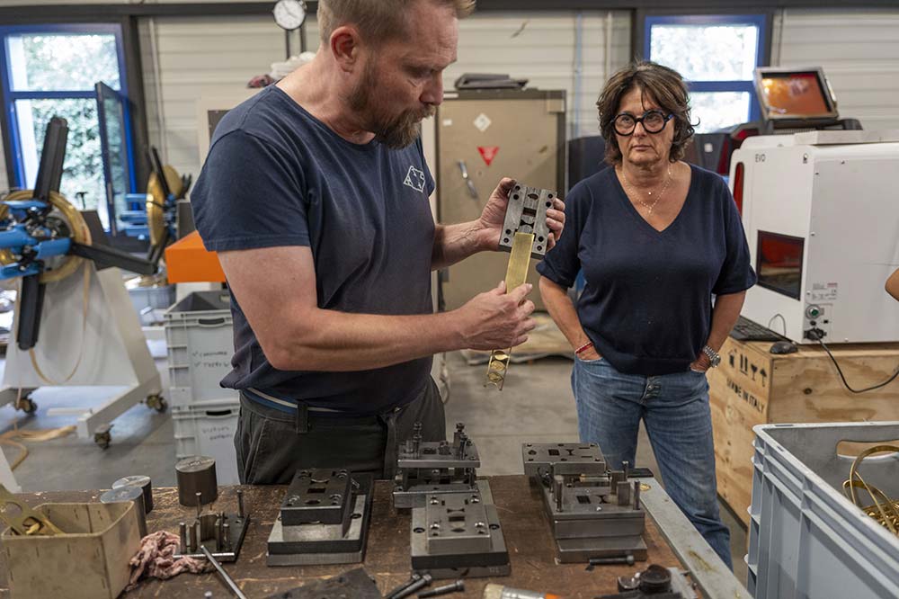 Un des artisans de l’entreprise nous explique la découpe à partir des rubans de métal.