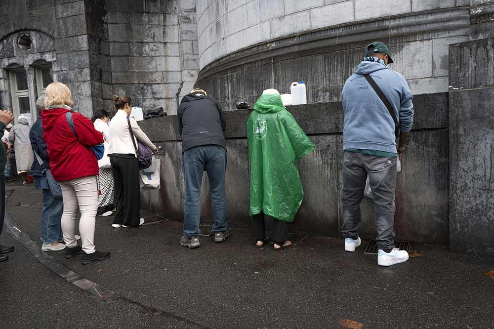 Sanctuaire - Beaucoup viennent remplir des bidons ou des gourdes, se rafraîchir, aux fontaines de l’eau qui jaillit de la grotte.