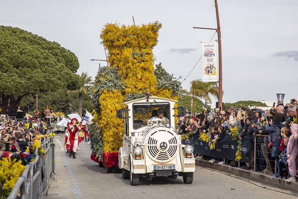  Le char de Mandelieu ouvre la marche, recouvert de mimosa, avec la tour du Château de La Napoule en vigie symbolique.