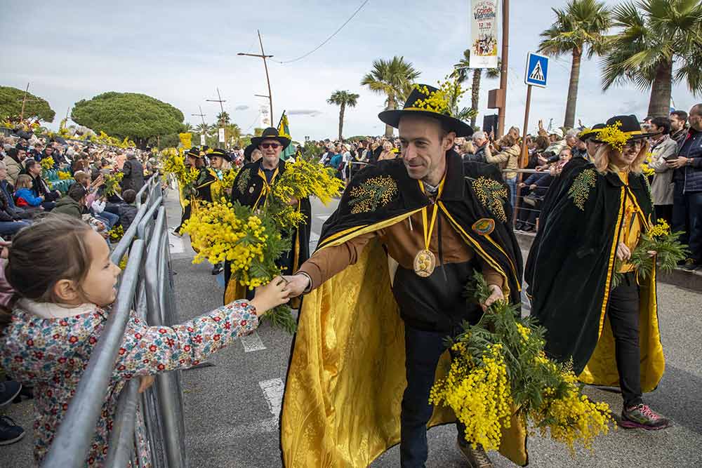 Mimosa - Les confréries défilent au plus près du public, partageant le mimosa.