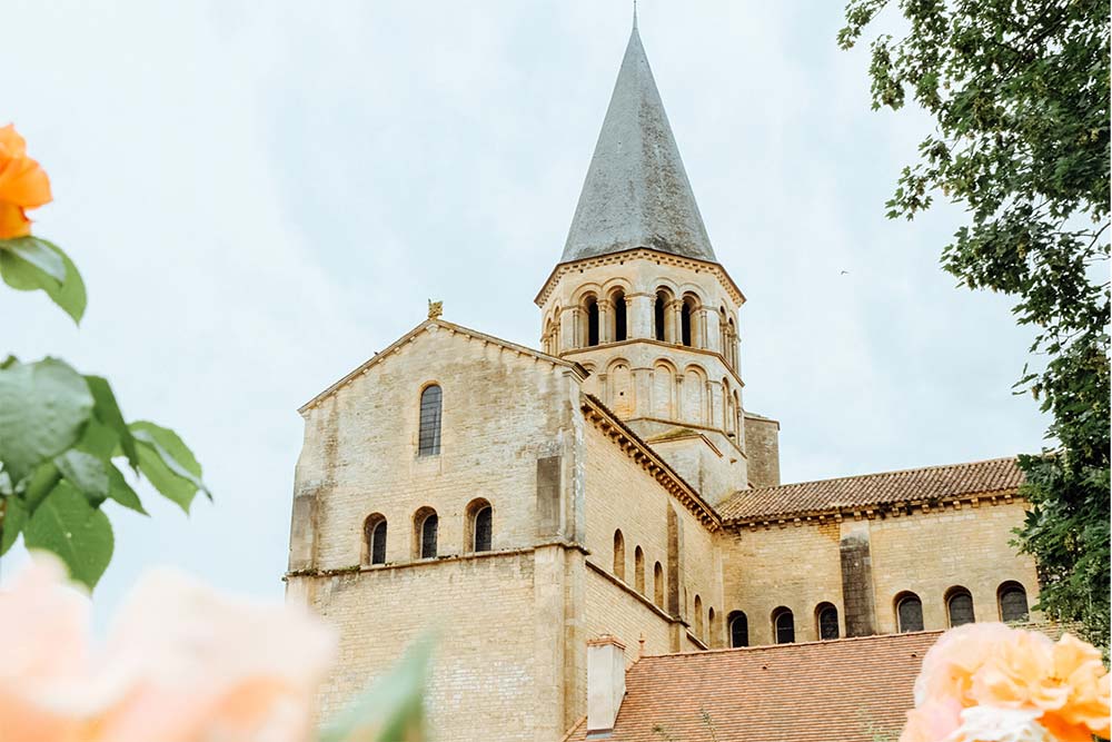 Villes Sanctuaires - La basilique romane du Sacré-Cœur siège entre la Bourbince et le parc des Chapelains depuis le XIIᵉ siècle.