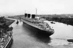 Le Normandie - Le paquebot Normandie (1935) remorqué vers la forme-écluse Joubert dans le bassin de Penhoët à Saint-Nazaire, le 4 mai 1935. ©Inconnu. Collection Saint-Nazaire Agglomération Tourisme - Écomusée. Fonds Chantiers de l’Atlantique.