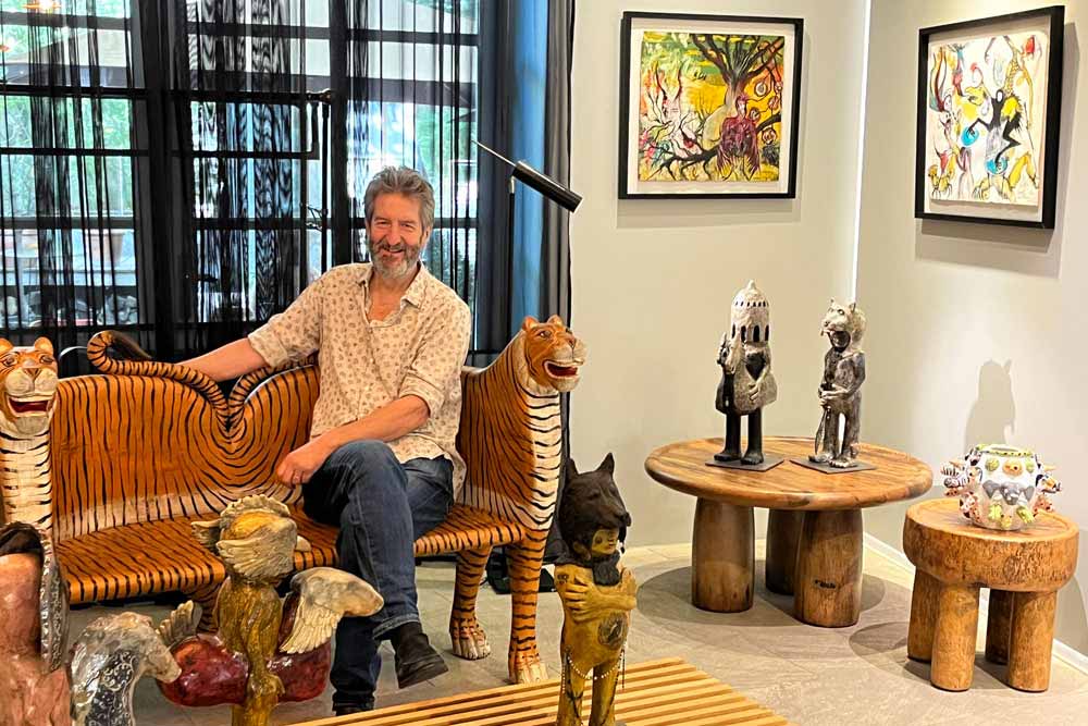 Partage des Arts - Frédéric Dol dans sa galerie. Derrière lui, des oeuvres sur papier d’Emmanuelle Renard et Sophie Sainrapt